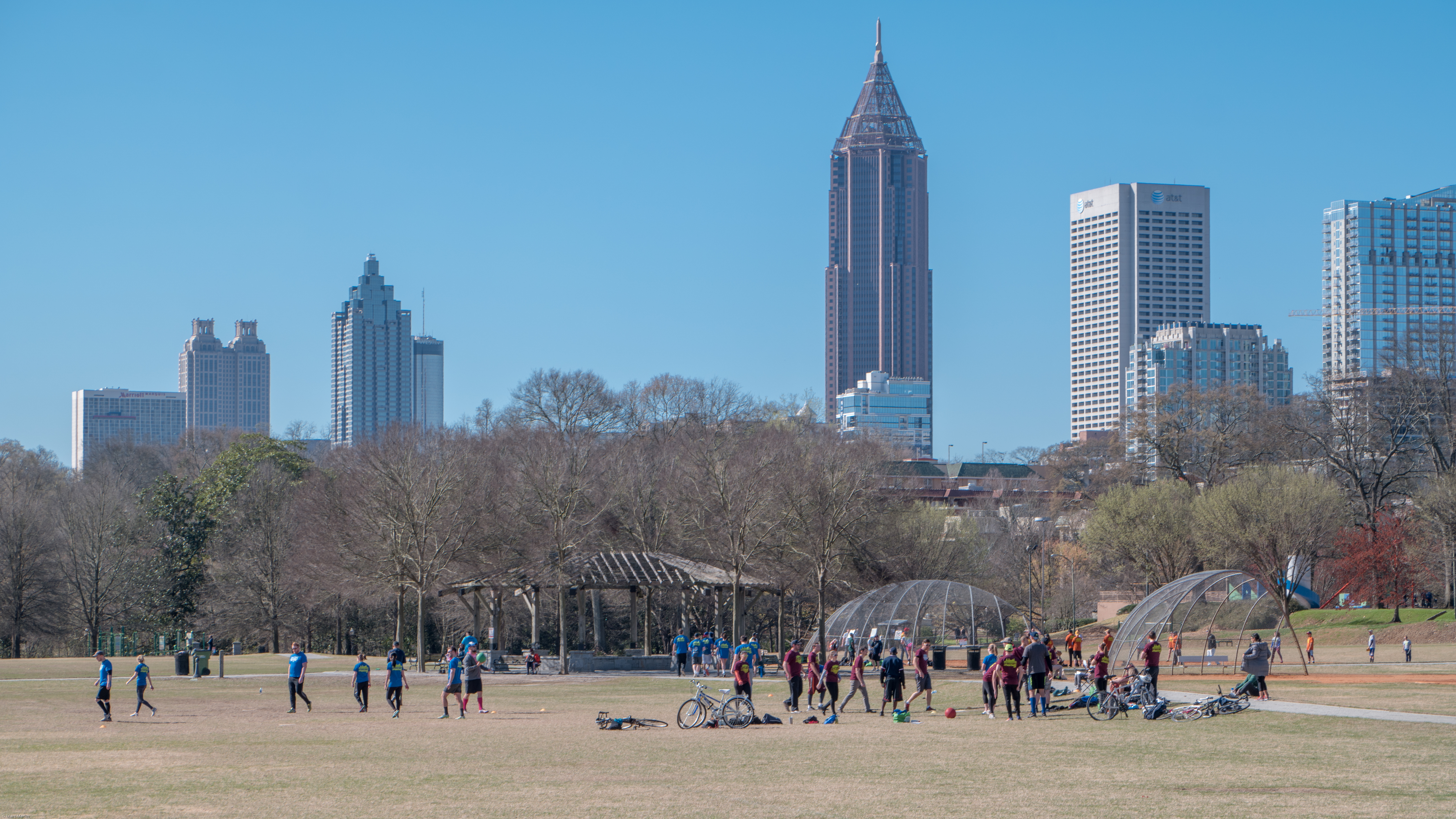 Kickball game in progress at a park on a sunny morning